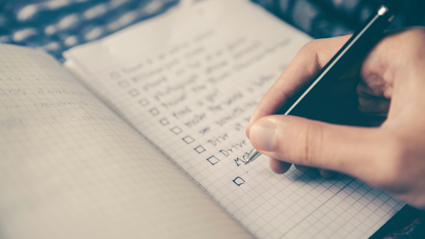 Laptop mit Checkliste und Notizbuch auf einem Schreibtisch zur Planung des Anbieterwechsels beim Internet