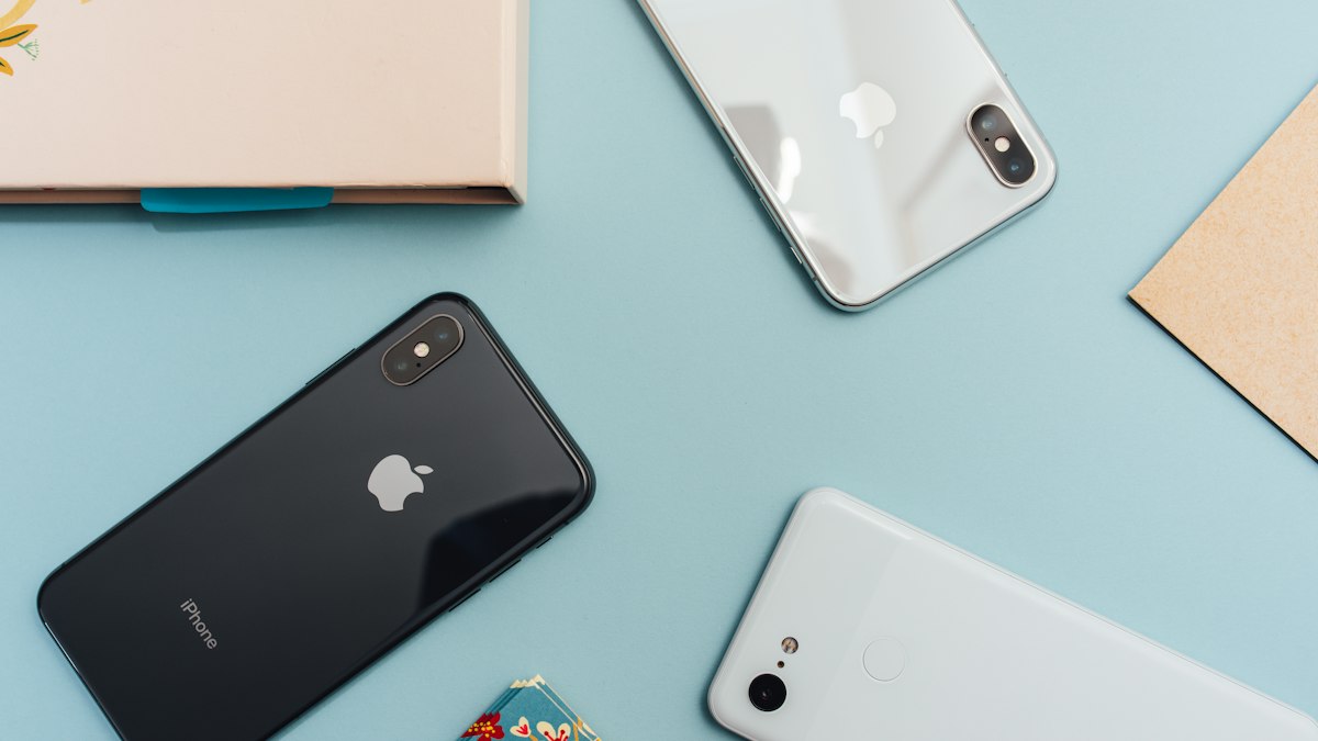 Smartphone mit Mobilfunk-Empfangsanzeige in der Hand vor einem Fenster